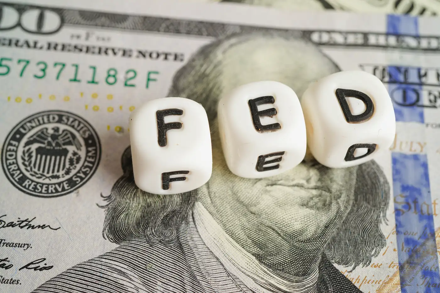 Billetes dólar y sobre ellos unos dados con la palabra FED