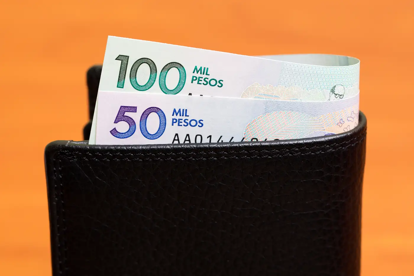 billetera con billetes de Colombia representando salario mínimo