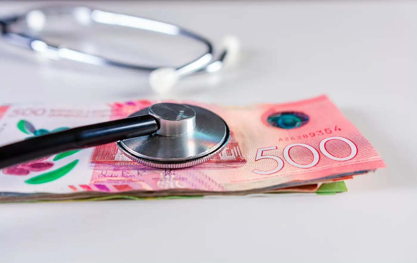 billetes sobre una mesa y un utencilio médico representando salud financiera