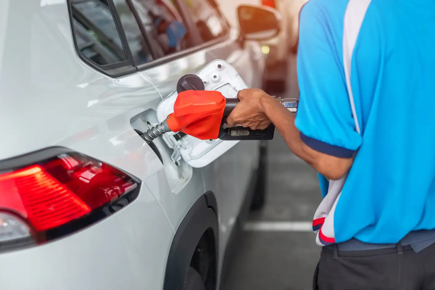hombre cargando combustible en estación de servicios