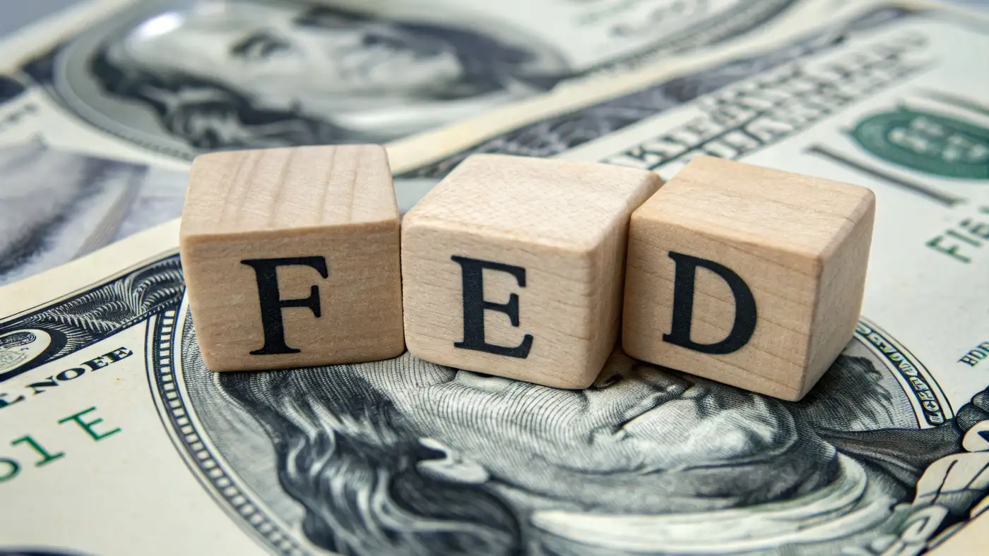 dados con la palabra FED sobre billetes dólar representando la decisión sobre tasas de interés