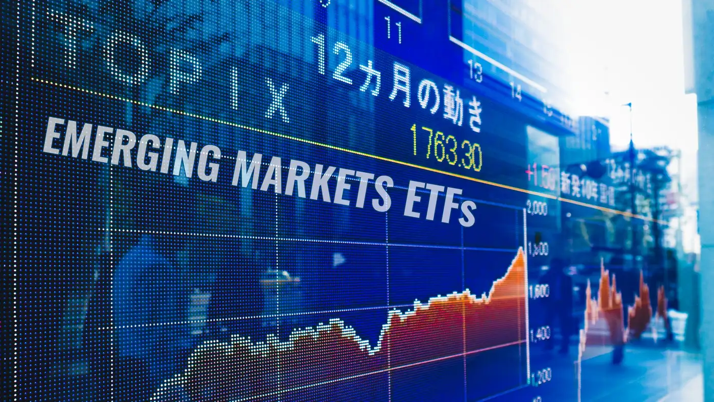 Comparativa visual de rentabilidad YTD 2026 entre ETFs IEMG EMXC y VWO con fondo oscuro y acentos verdes